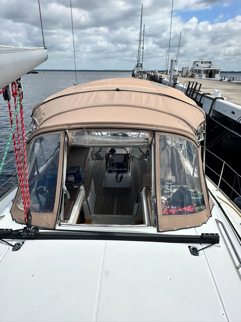 Slide: The Image of 2011 Jeanneau Sun Odyssey 45 DS sailboat docked, featuring a beige canopy and spacious deck. - 11