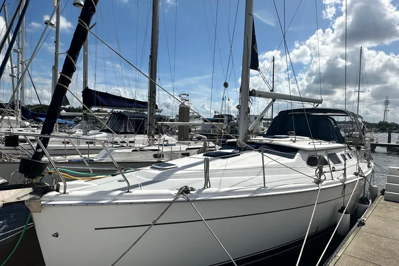 Slide: The Image of 2006 Hunter 41 Deck Salon sailboat docked at marina under blue sky. - 5
