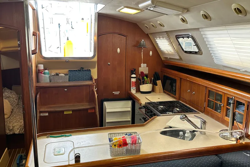 Slide: The Image of Interior of 2006 Hunter 41 Deck Salon yacht, featuring a well-equipped kitchen area. - 61