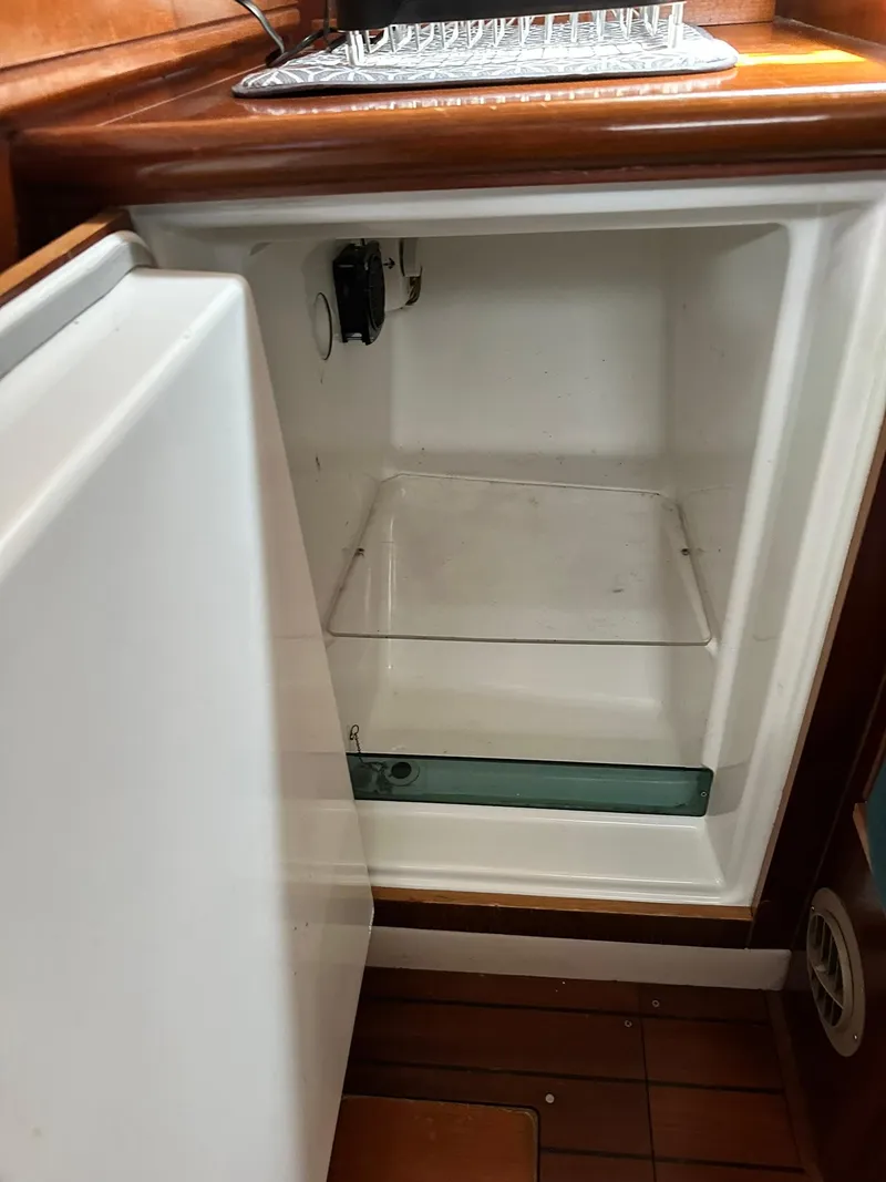 Slide: The Image of Open refrigerator inside a 1998 Beneteau 381 sailboat, showcasing interior shelving. - 30