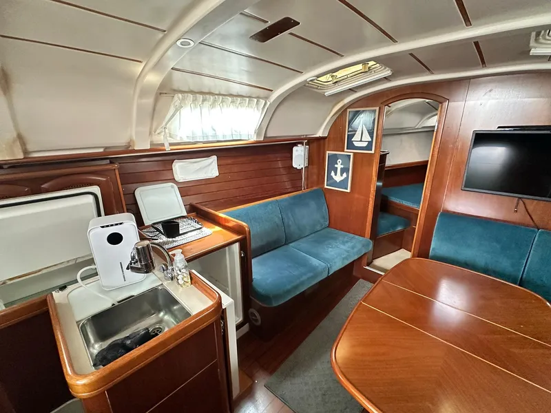 Slide: The Image of Interior of 1998 Beneteau 381 sailboat with cozy seating and wooden finishes. - 32