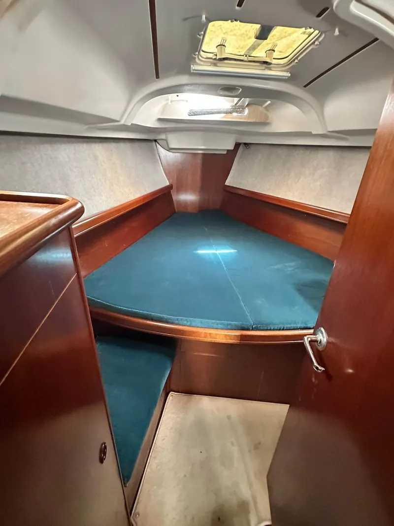 Slide: The Image of Interior cabin of a 1998 Beneteau 381 sailboat with blue cushions and wood finish. - 34