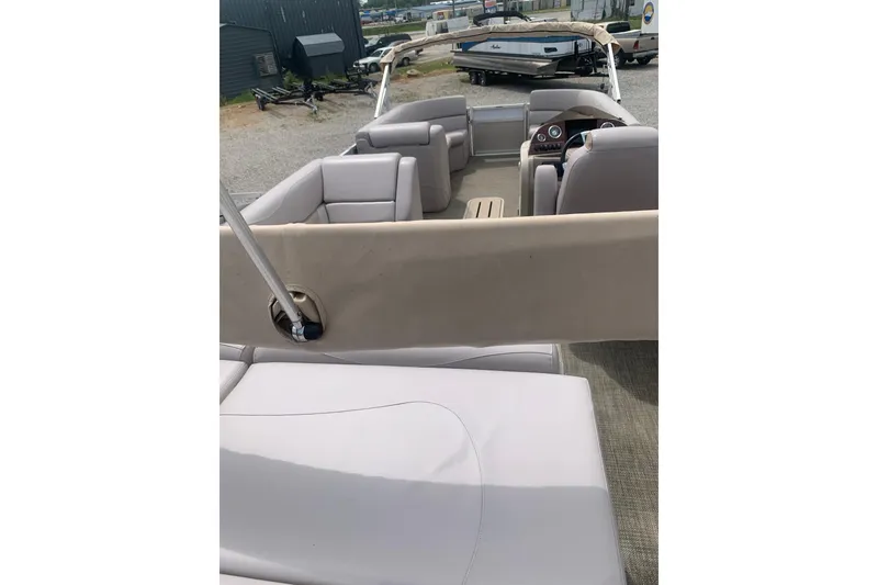 Slide: The Image of 2015 Avalon Windjammer Elite 25' pontoon boat interior with beige seating and helm. - 14