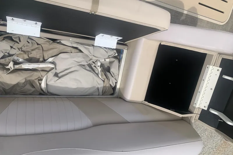 Slide: The Image of Open storage compartment in 2015 Avalon Windjammer Elite boat, revealing interior fabric and seating. - 20