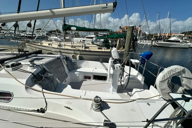Slide: The Image of 2008 Catalina 320 sailboat docked in a marina, surrounded by other boats. - 22