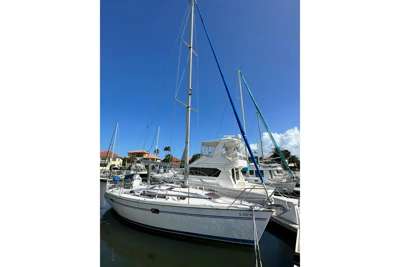 Slide: The Image of Catalina 320 sailboat, 2008 model, docked in a marina under clear blue skies. - 4