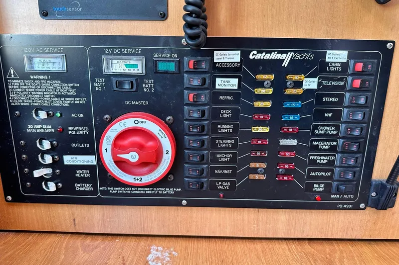 Slide: The Image of Electrical control panel of a 2008 Catalina 320 yacht with various switches and indicators. - 50