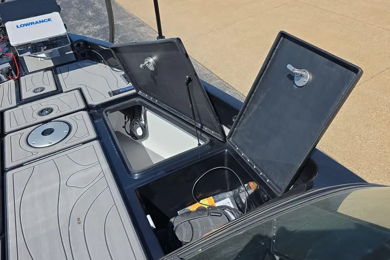 Slide: The Image of 2026 Yar-Craft 219TFX boat deck with open storage compartments and Lowrance electronics. - 13