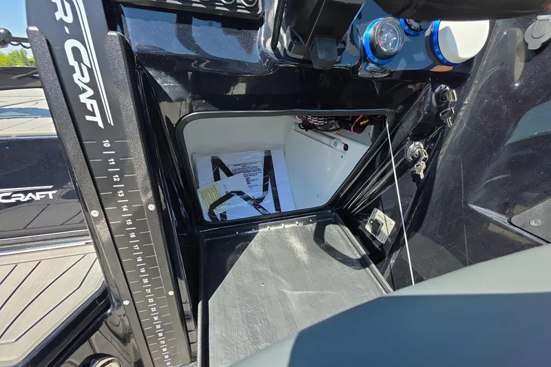 Slide: The Image of 2026 Yar-Craft 219TFX boat interior storage compartment with keys and gauges visible. - 20