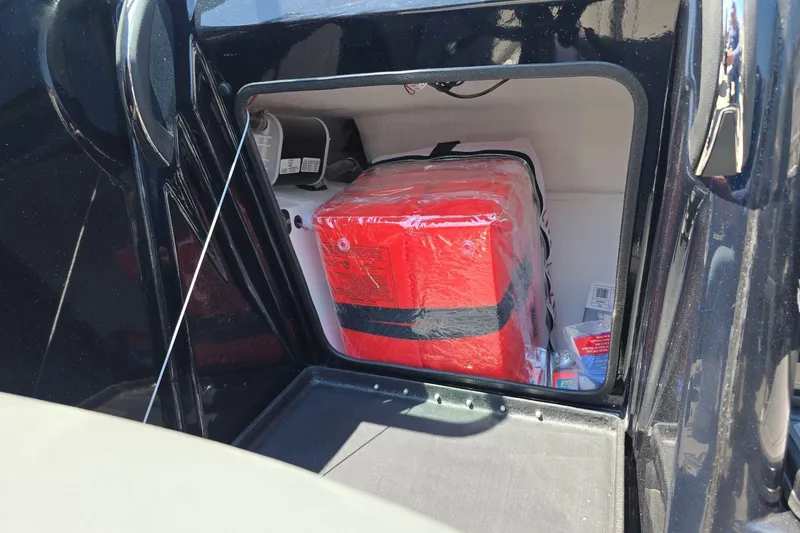 Slide: The Image of Storage compartment of 2026 Yar-Craft 219TFX boat with red safety equipment. - 21