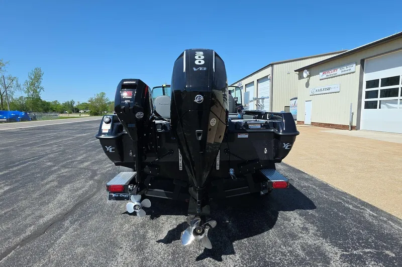 Slide: The Image of 2026 Yar-Craft 219TFX boat with dual Mercury outboard motors, parked outside a service building. - 4