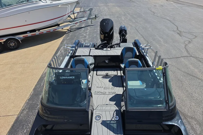 Slide: The Image of 2026 Yar-Craft 219TFX fishing boat with dual consoles and outboard motor, parked on pavement. - 6