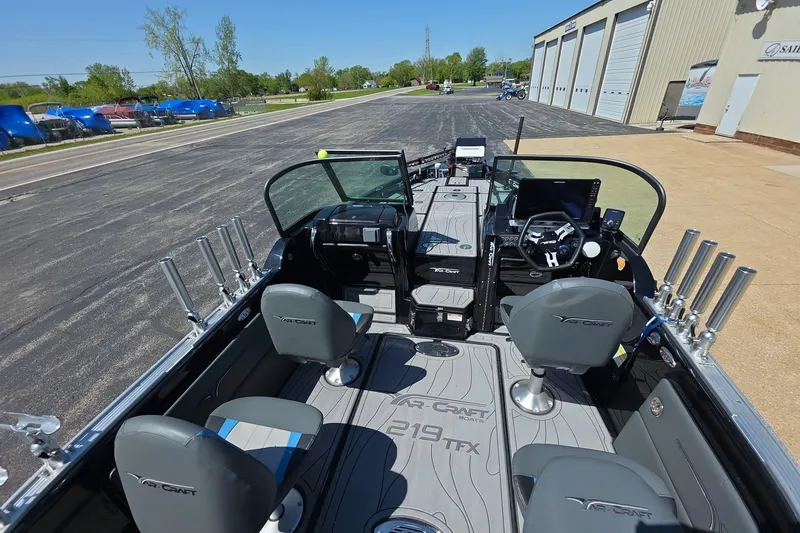 Slide: The Image of 2026 Yar-Craft 219TFX boat interior with seating and control panel, parked outdoors. - 7