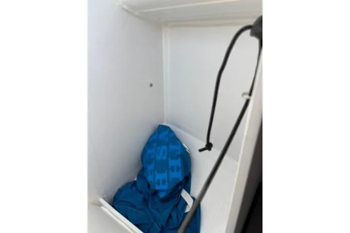 Slide: The Image of Storage compartment in 2024 Beneteau First 27 sailboat with blue fabric inside. - 12