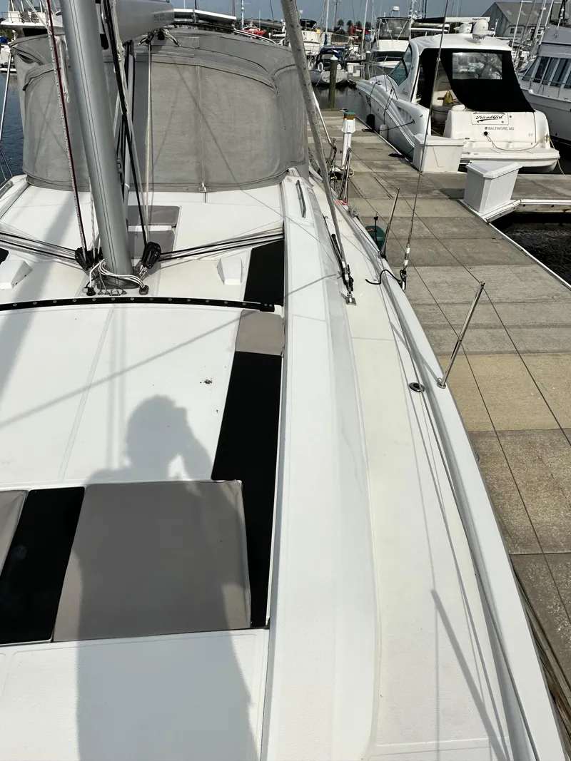 Slide: The Image of 2023 Beneteau Oceanis 46.1 sailboat docked at marina, showcasing deck and mast. - 10