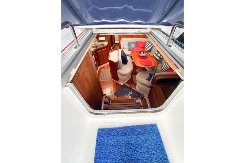 Slide: The Image of Interior view of a 1996 Hunter 430 sailboat, featuring cozy seating and nautical decor. - 25