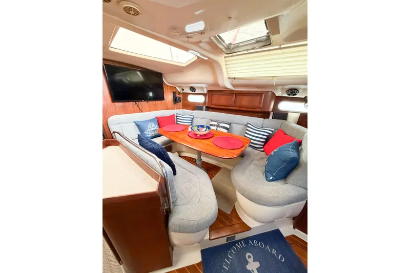 Slide: The Image of Cozy interior of 1996 Hunter 430 sailboat with plush seating and nautical decor. - 28