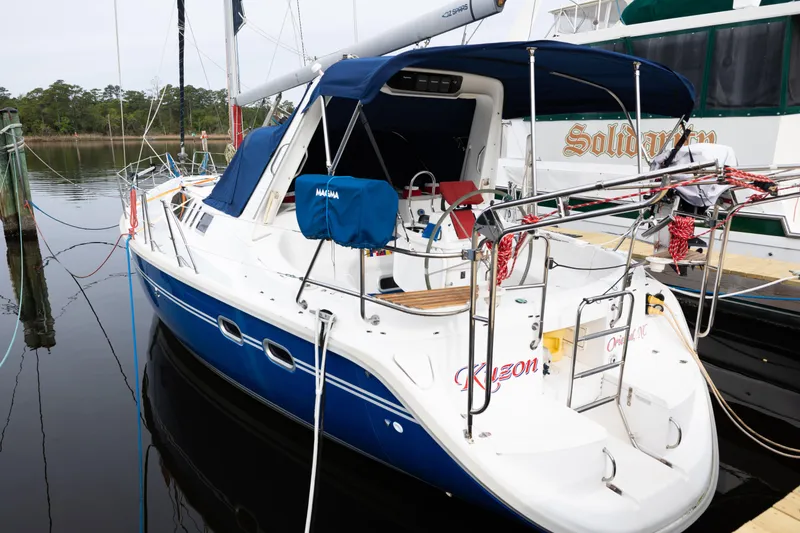 Slide: The Image of Hunter 430 sailboat from 1996 docked, featuring blue hull and canopy. - 3