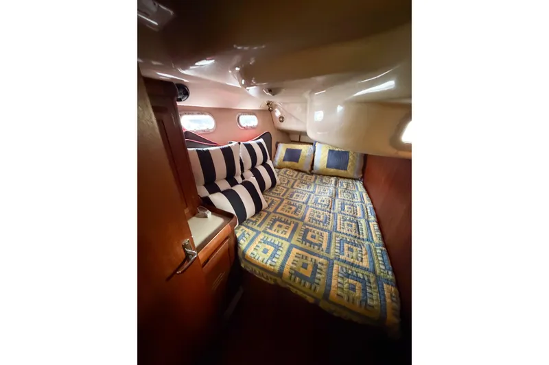 Slide: The Image of Cozy cabin interior of 1996 Hunter 430 sailboat with patterned bedding and striped pillows. - 30