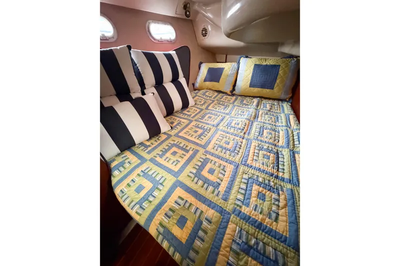 Slide: The Image of Cozy cabin bed in 1996 Hunter 430 yacht with patterned quilt and striped pillows. - 31