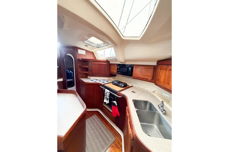 Slide: The Image of Interior of a 1996 Hunter 430 sailboat kitchen with wooden cabinets and modern amenities. - 35