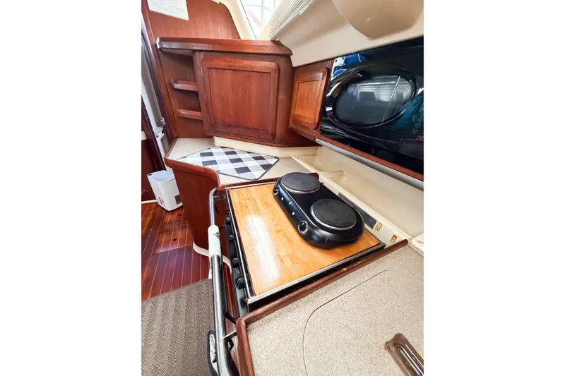 Slide: The Image of Compact kitchen area in a 1996 Hunter 430 sailboat with stove and microwave. - 37
