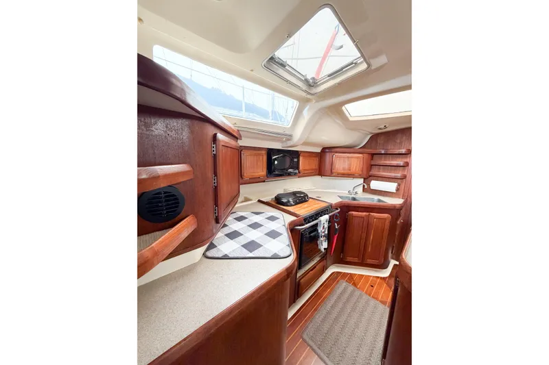Slide: The Image of Interior of 1996 Hunter 430 sailboat kitchen with wooden cabinetry and modern amenities. - 38