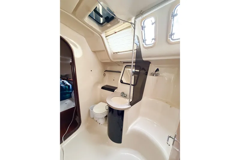 Slide: The Image of Bathroom interior of a 1996 Hunter 430 sailboat, featuring a compact design with a toilet and sink. - 39
