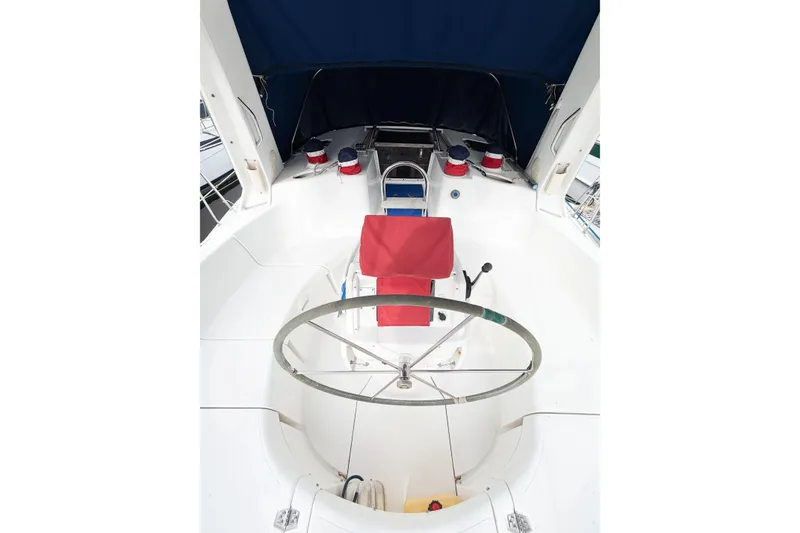 Slide: The Image of Cockpit of a 1996 Hunter 430 sailboat with red seating and blue canopy. - 4