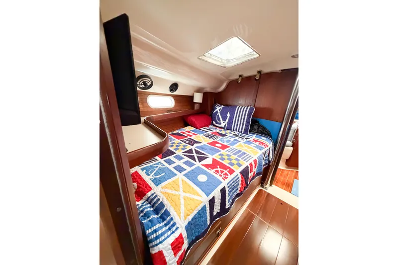 Slide: The Image of Cozy cabin interior of 1996 Hunter 430 sailboat with nautical-themed bedding. - 47