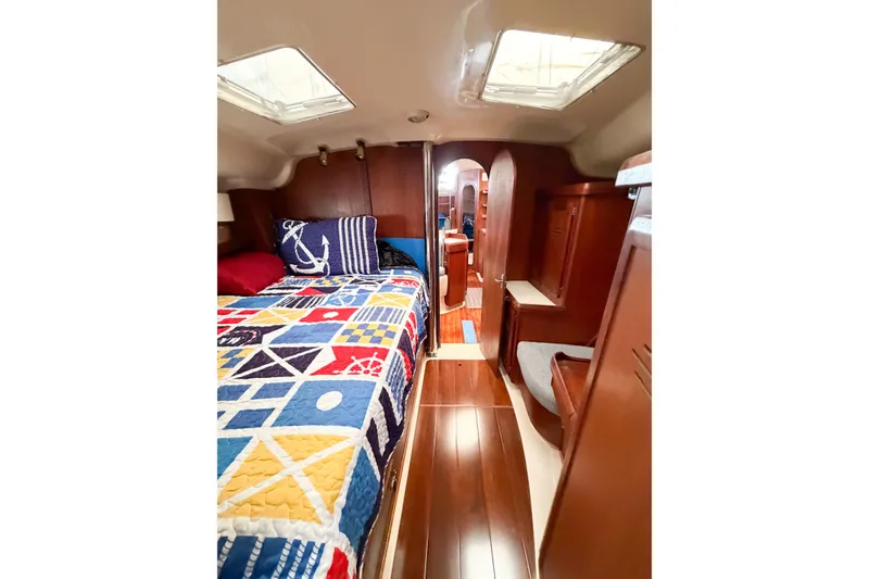 Slide: The Image of Interior of 1996 Hunter 430 sailboat with colorful bedding and wooden finishes. - 48