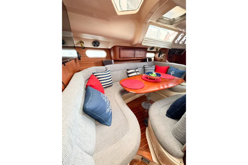 Slide: The Image of Interior of a 1996 Hunter 430 sailboat with cozy seating and colorful cushions. - 52