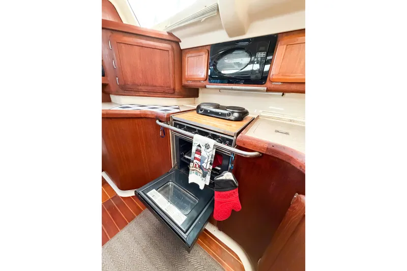 Slide: The Image of Hunter 430 yacht kitchen interior with wooden cabinets, oven, and microwave, 1996 model. - 54