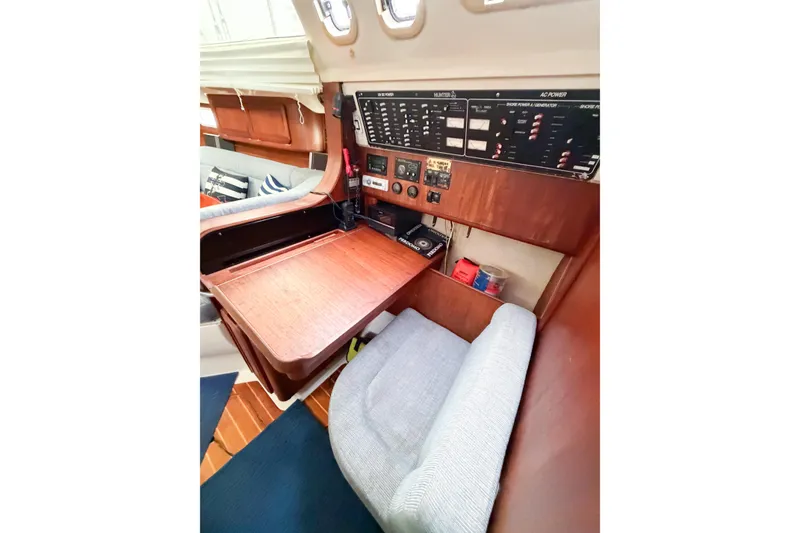 Slide: The Image of Interior of a 1996 Hunter 430 sailboat featuring a navigation station with control panel. - 57