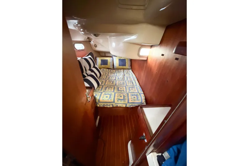 Slide: The Image of Cozy cabin interior of 1996 Hunter 430 sailboat with patterned bedding and wooden finish. - 60