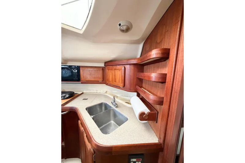 Slide: The Image of Interior of 1996 Hunter 430 yacht kitchen with wooden cabinets and dual sink. - 63