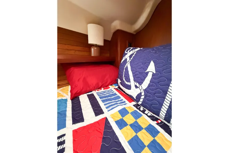 Slide: The Image of Cozy cabin bed in 1996 Hunter 430 yacht with nautical-themed bedding and lamp. - 64