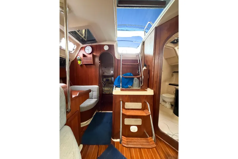 Slide: The Image of Interior of a 1996 Hunter 430 sailboat, featuring wood paneling and compact living space. - 75