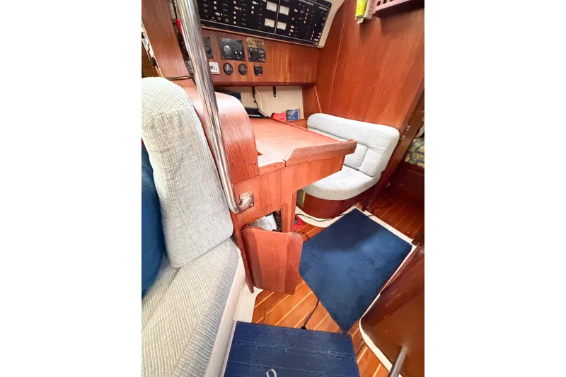 Slide: The Image of Interior of a 1996 Hunter 430 sailboat featuring a navigation station and seating area. - 76