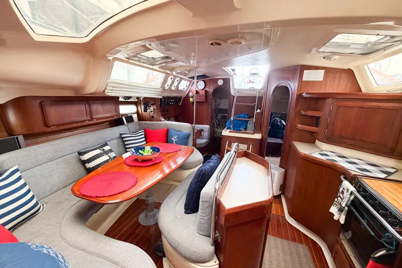 Slide: The Image of Interior of a 1996 Hunter 430 sailboat with cozy seating and wooden finishes. - 78