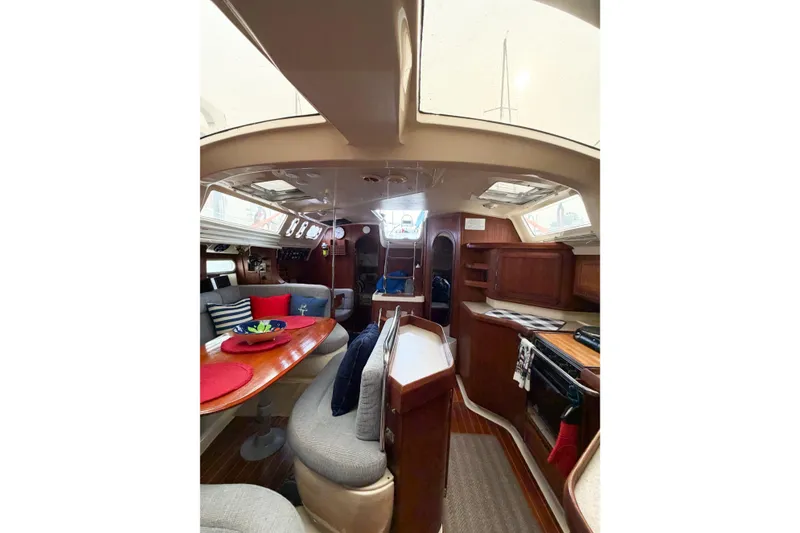 Slide: The Image of Interior of a 1996 Hunter 430 sailboat with cozy seating and wooden cabinetry. - 79