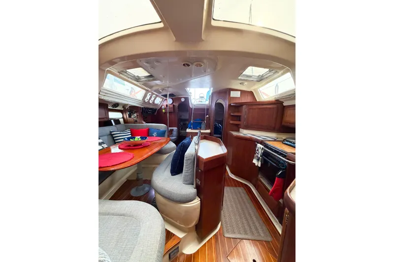 Slide: The Image of Interior of a 1996 Hunter 430 sailboat with cozy seating and wooden cabinetry. - 80