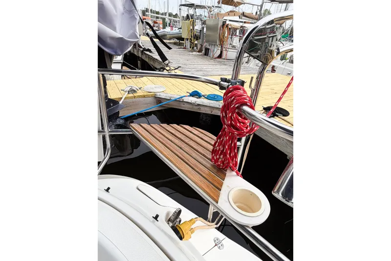 Slide: The Image of Hunter 430 sailboat deck with red rope and wooden platform, docked at marina. - 85