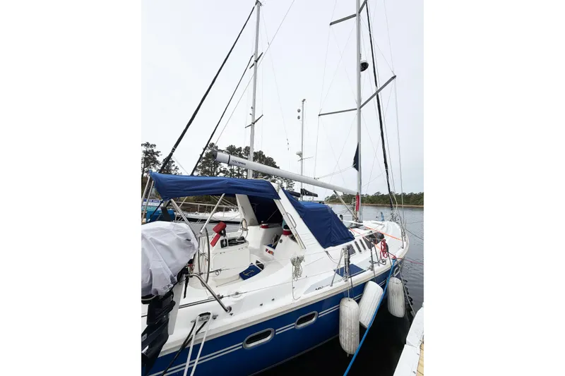 Slide: The Image of Sailboat Hunter 430, 1996 model, docked with blue canopy and white hull. - 86