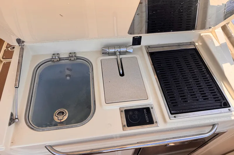 Slide: The Image of Outdoor kitchen setup on a 2018 Chris-Craft Calypso 30 boat, featuring a sink and grill. - 11