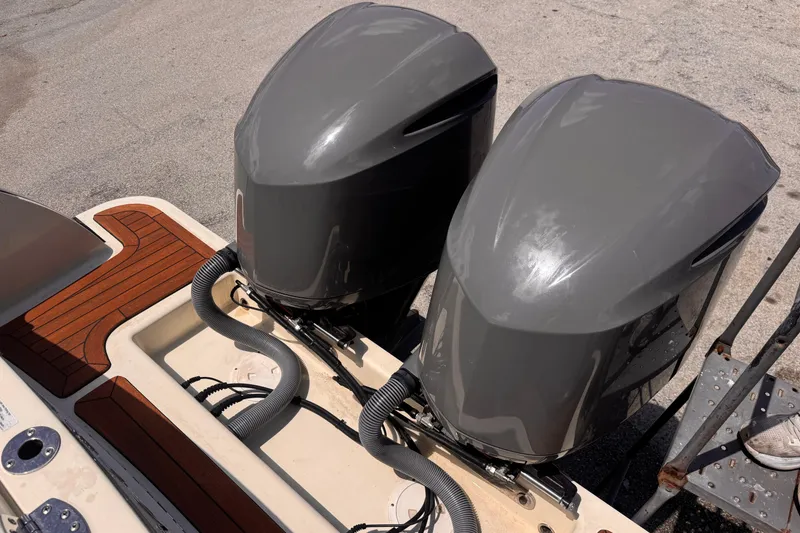Slide: The Image of Twin outboard engines on a 2018 Chris-Craft Calypso 30 boat, docked on a sunny day. - 16