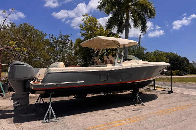 Slide: The Image of 2018 Chris-Craft Calypso 30 boat on stands, under a clear blue sky. - 17