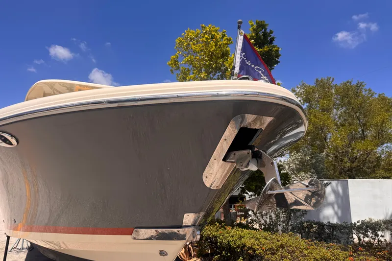 Slide: The Image of 2018 Chris-Craft Calypso 30 boat bow with flag, under clear blue sky. - 19
