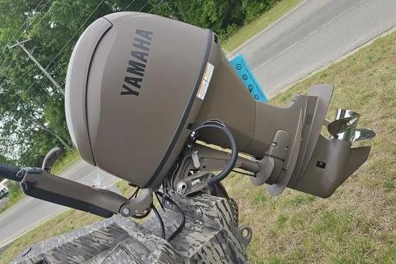 Slide: The Image of Outboard motor on a 2026 Havoc 1760 VJST boat, parked on grass. - 13