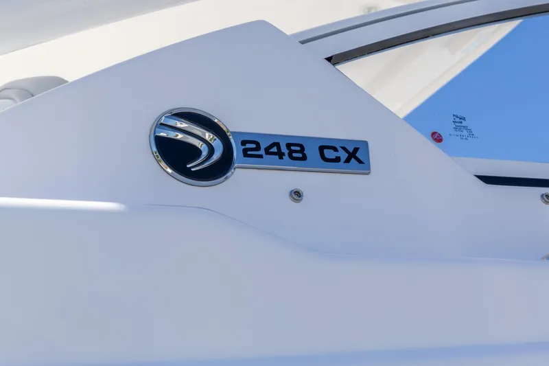 Slide: The Image of 2026 Edgewater 248CX Crossover boat emblem on white surface under blue sky. - 11